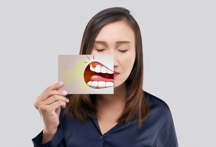 Girl holding teeth image of gum irritation